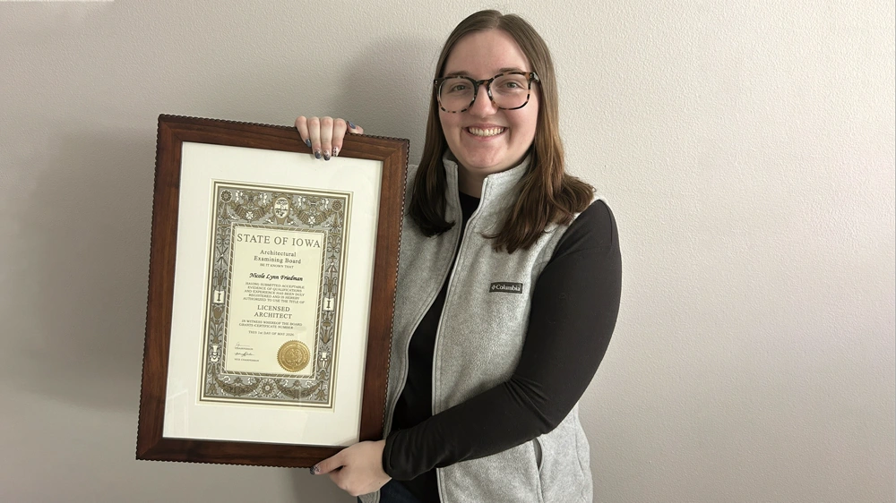 MA Architect Nicole Friedman proudly holds her Licensed Architect Certificate issued by the State of Iowa Licensing Board May 1, 2026.